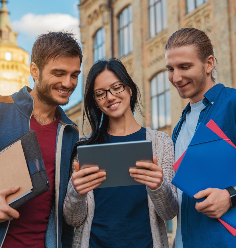 a-group-of-young-multi-ethnic-group-of-student-in-university-smiling-and-looking-at-the-tablet.jpg